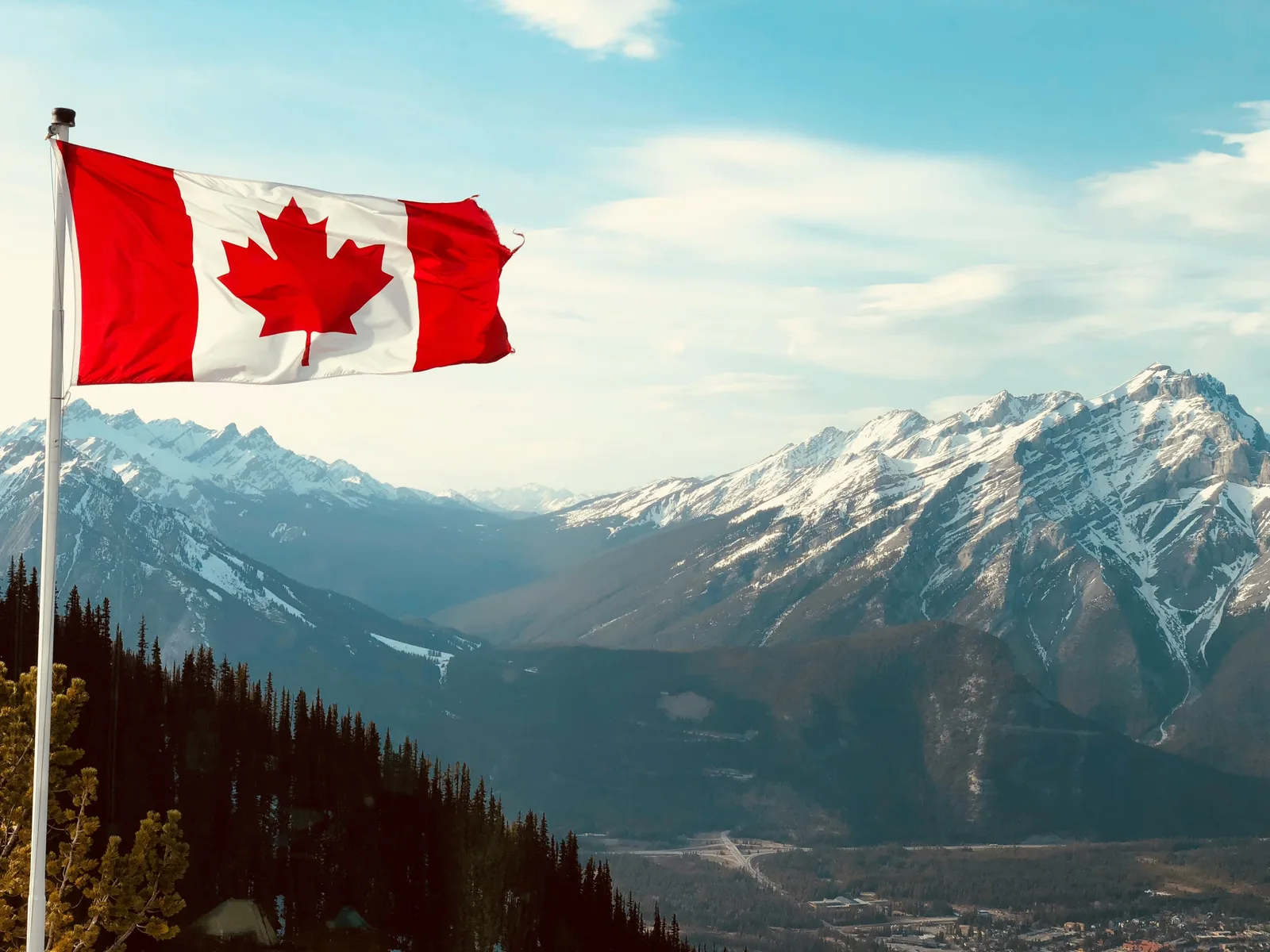 Canadian flag above the Rocky Mountains